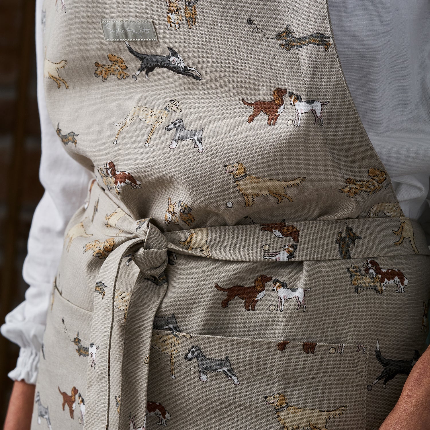 Close up image of Sophie Allport's Doggy Daycare print featured on her adult apron