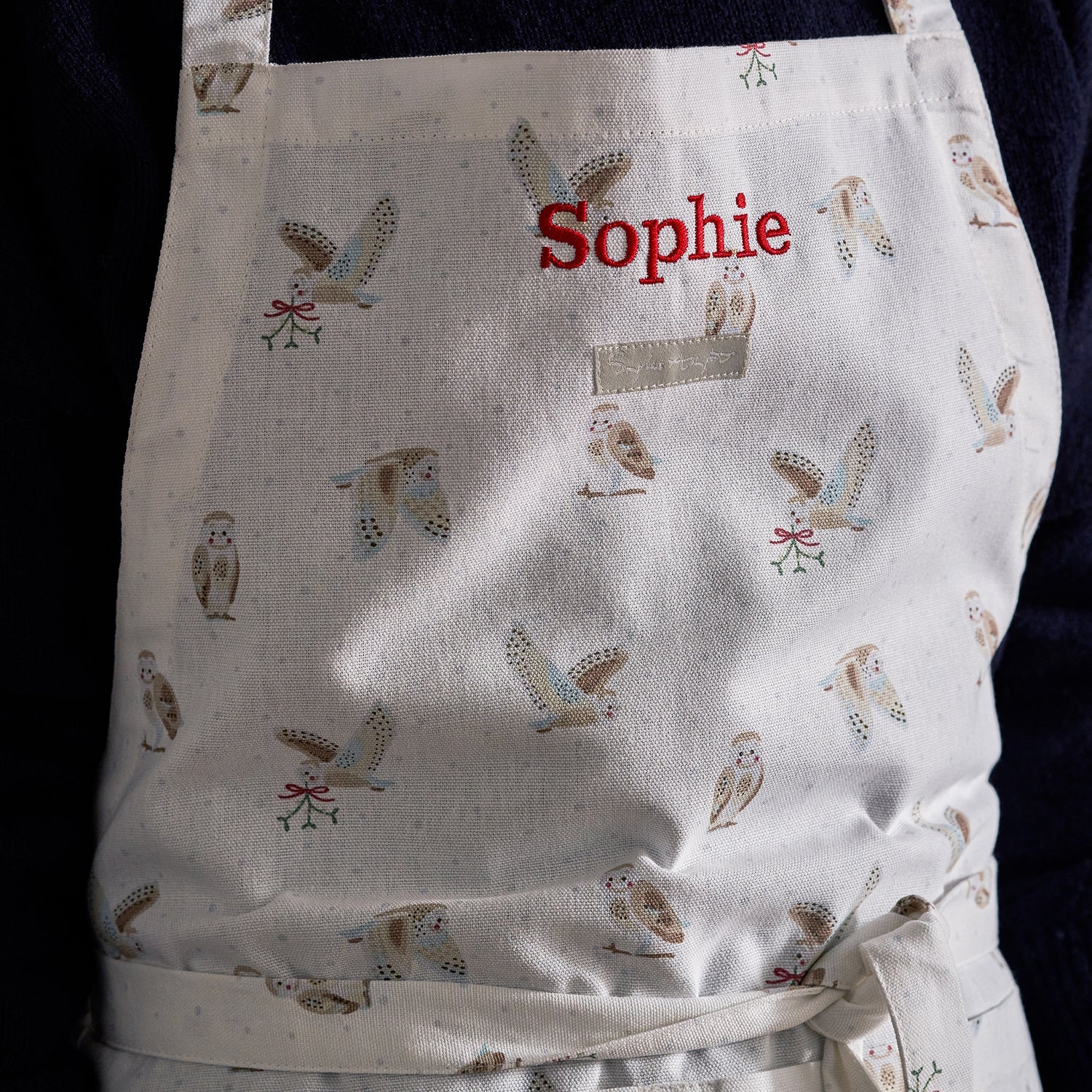 Close up of Sophie Allport's Snowy Owl adult apron which has been personalised with the words Sophie