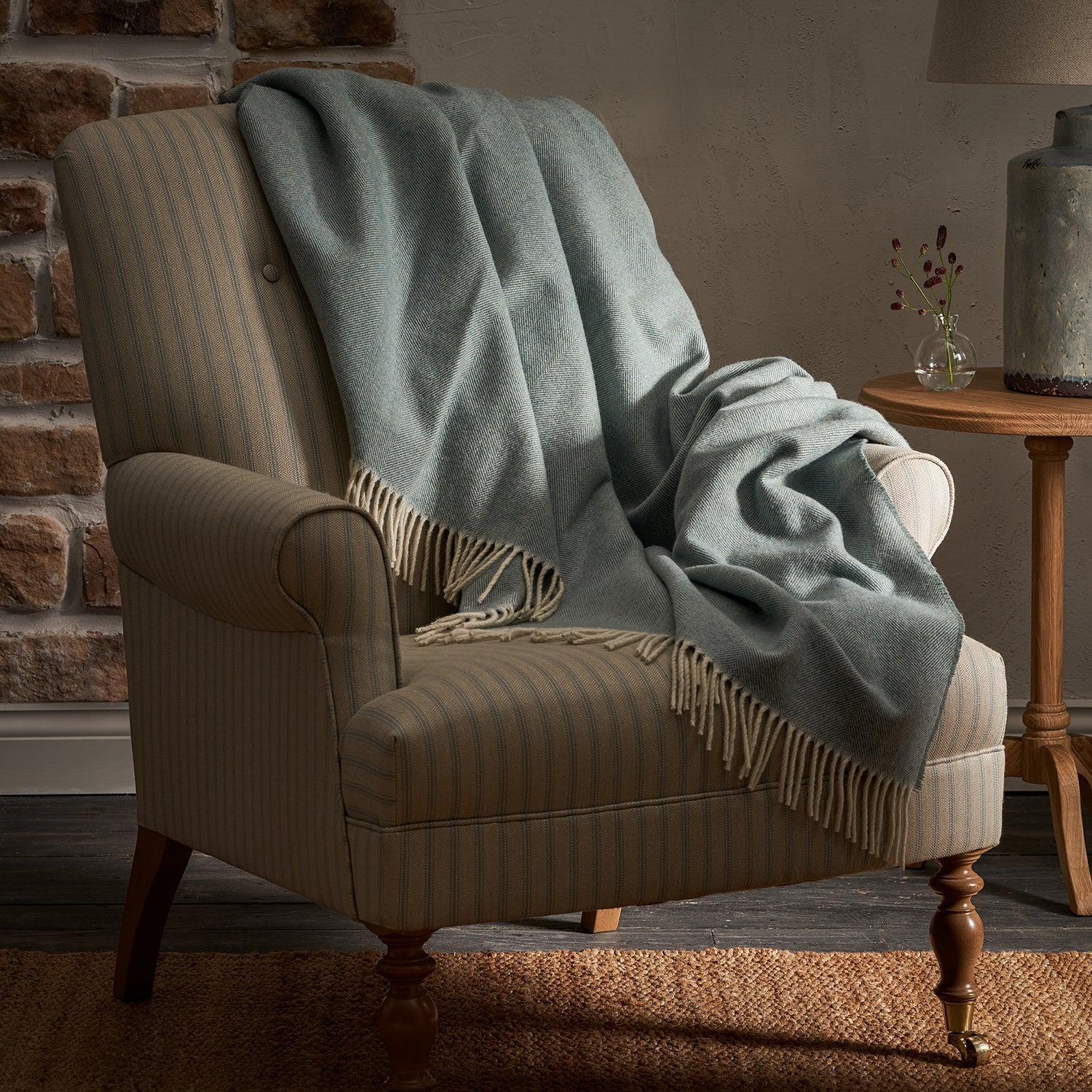 Sophie Allport's Blue Lambswool Throw placed on striped armchair