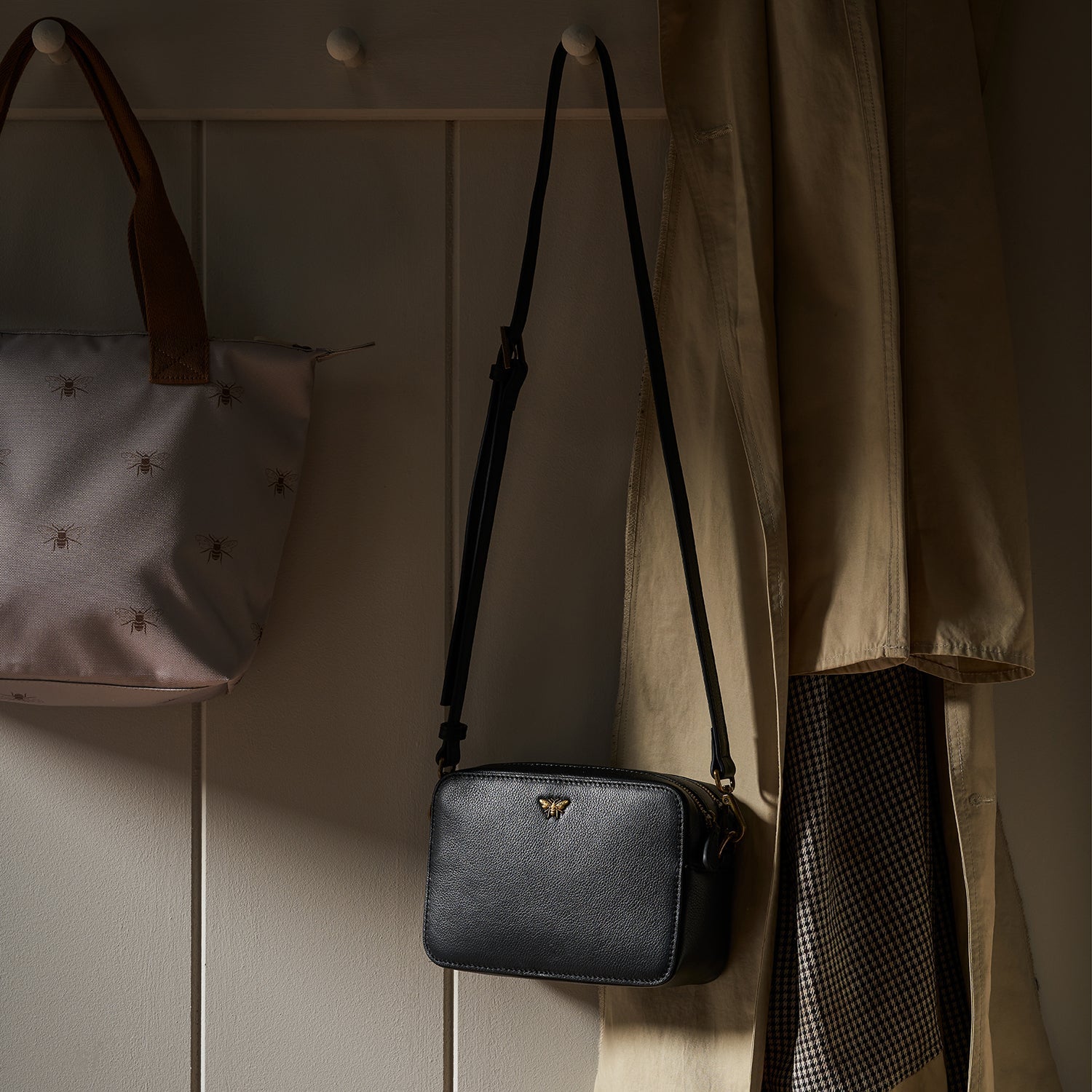 Bees Leather Camera Bag by Sophie Allport hung on peg