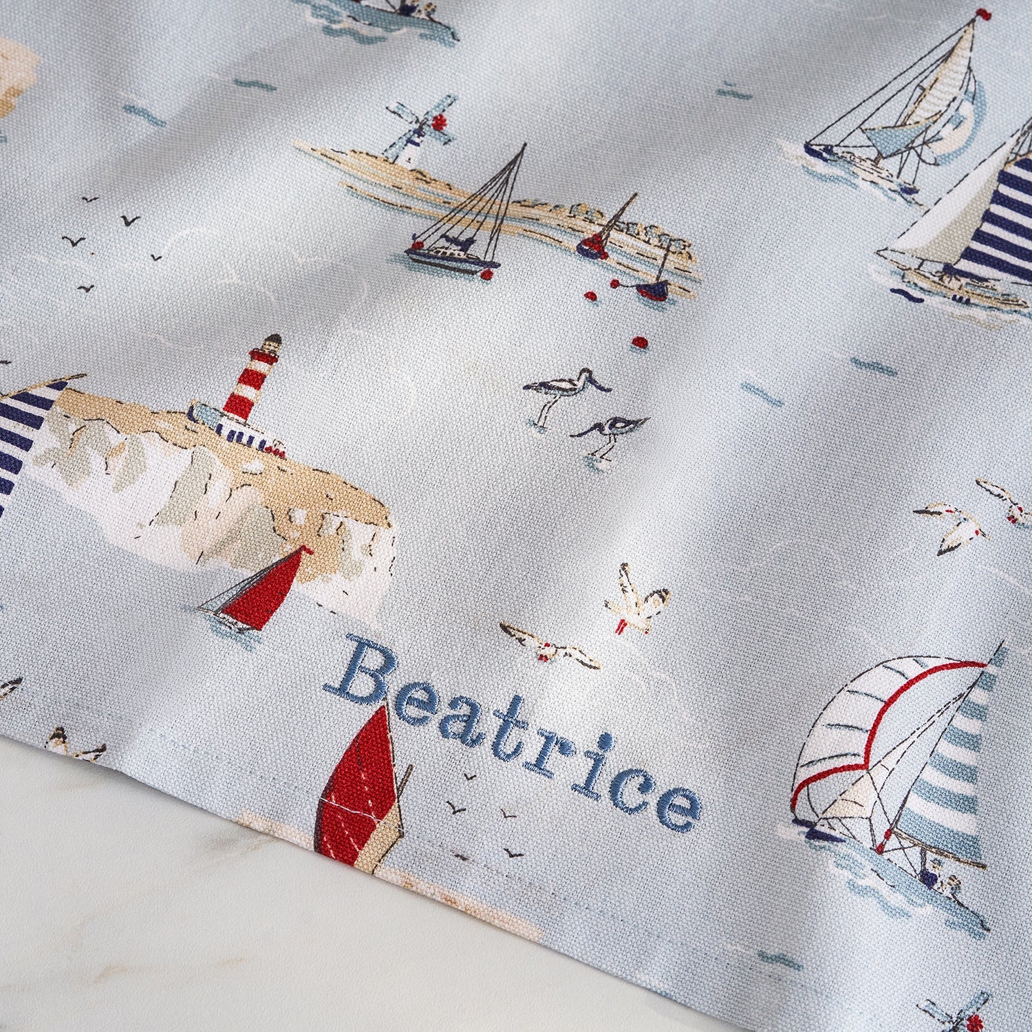 Blue tea towel with coastal boats print by Sophie Allport personalised